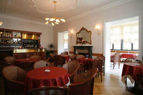 um restaurante com mesas e cadeiras e um espelho em Hotel Villa Rosy em Premeno