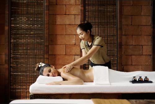 a woman getting a massage in a hot tub at JW Marriott Phuket Resort and Spa in Mai Khao Beach