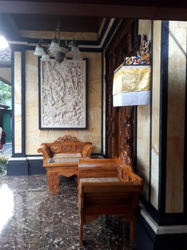 a wooden bench in a room with a wall at Indy House in Ubud