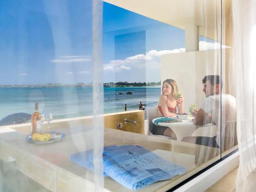a man and a woman sitting in a bath tub at White Bay in Fontane Bianche