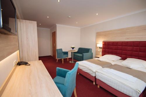 a hotel room with a bed and a table and chairs at Hotel Texicana in Sulechów