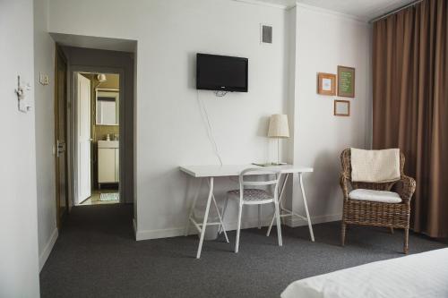 a hotel room with a desk and a tv at SAKÀ Vacation House in Druskininkai