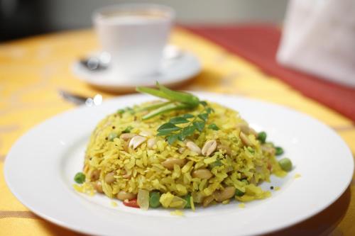 a white plate of food with rice on a table at Hotel Cama in Chandīgarh