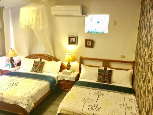 a bedroom with two beds and a window at Sunny Villa Homestay in Wujie