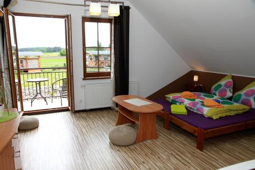 a room with a bed and a table and a balcony at Pokoje do Wynajęcia - Sen na Mazurach in Mikołajki