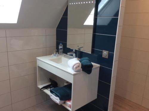 a bathroom with a sink and a mirror at Les Chambres Chez Christine in Ottrott