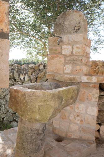 a stone sink in front of a stone wall at B&B La Grave in Noci