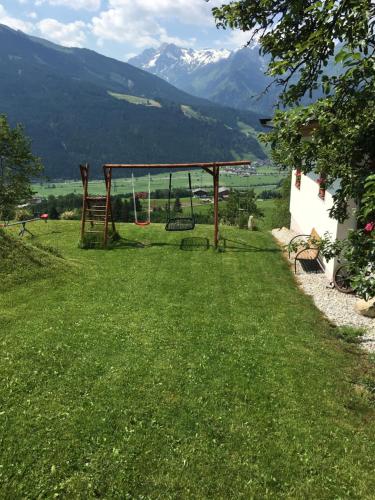 a playground in a field with mountains in the background at Untersteinhof in Mittersill