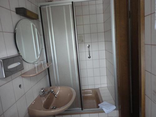 a bathroom with a sink and a shower with a mirror at Haus Volkesbach in Liesen