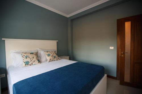 een slaapkamer met een bed met een blauwe en witte deken bij Bliss Residence - Aquamarine in Constanţa