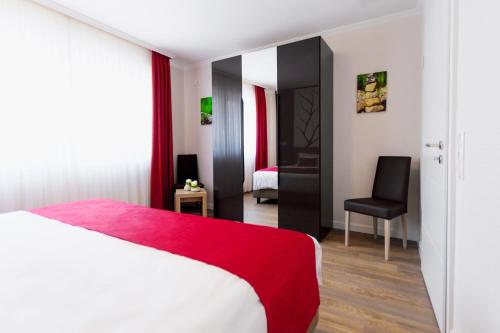 a bedroom with a red and white bed and a chair at Ferienwohnung Burgblick in Bullay