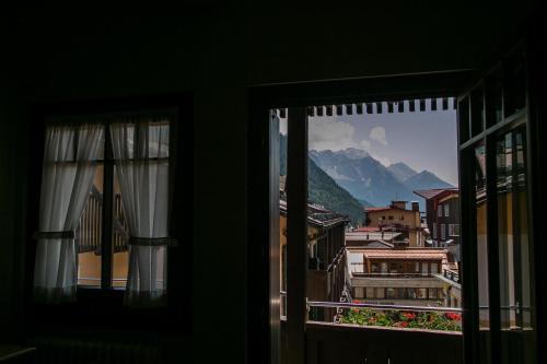 a window with a view of a mountain at Hotel Posta R.T.A. in Madonna di Campiglio