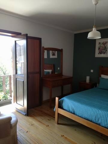 a bedroom with a bed and a mirror at Abrigo da Geira House in Campo do Gerês