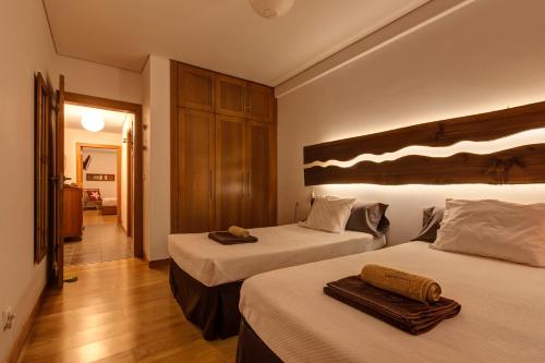 a hotel room with two beds with towels on them at epicenter SANTACRUZ in Lagoa