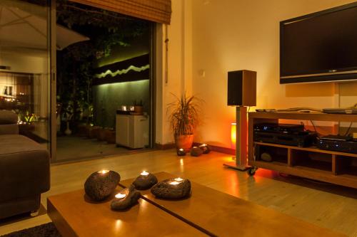 a living room with a tv and a table at epicenter SANTACRUZ in Lagoa