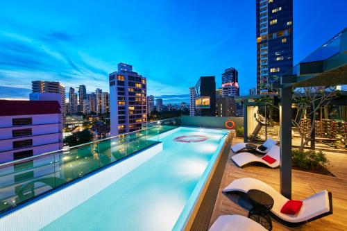 una piscina en la azotea en un edificio con vistas al perfil urbano en Oakwood Studios Singapore, en Singapur