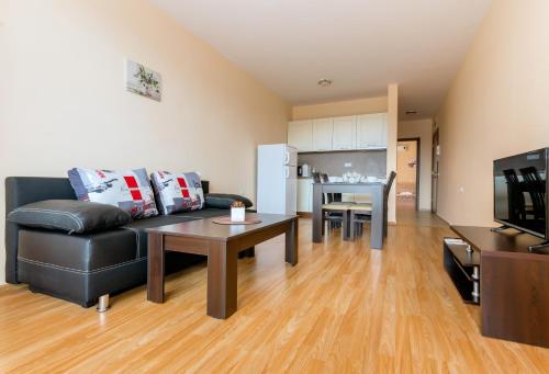 uma sala de estar com um sofá de couro preto e uma mesa em Oxygen Apartments em Sveti Vlas