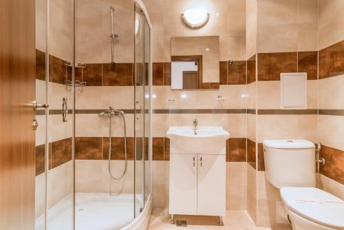 een badkamer met een douche, een toilet en een wastafel bij Oxygen Apartments in Sveti Vlas