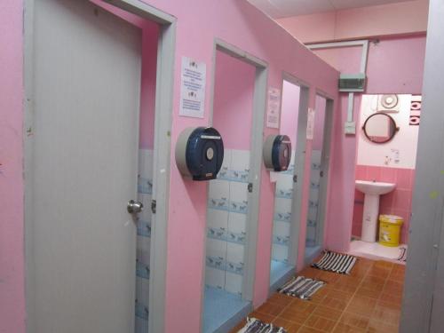 um corredor de uma casa de banho com paredes cor-de-rosa em Lucky Homestay em Haad Rin