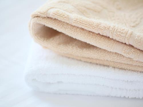 a stack of white towels on a white table at APA Hotel Hamamatsu Eki Minami in Hamamatsu