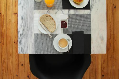 un tavolo con una tazza di caffè e un piatto di pane di Porto Music Guest House a Porto