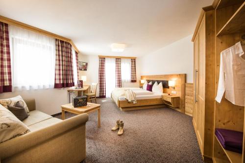 a hotel room with a bed and a couch at Hotel Salzburgerhof in Flachau