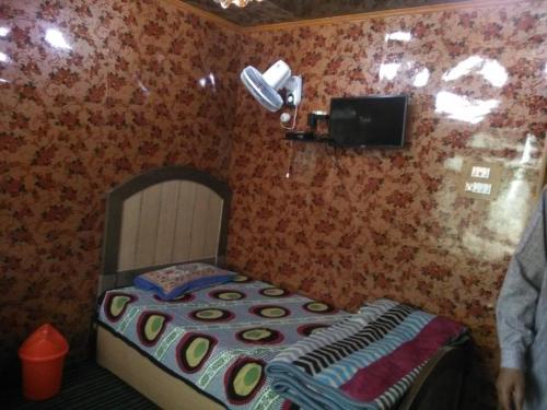 a small bedroom with a bed and a tv at Kashmir naaz in Srinagar
