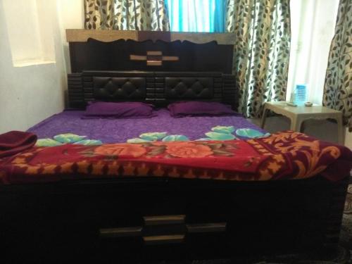 a bedroom with a large bed with a red blanket at Kashmir naaz in Srinagar
