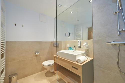 a bathroom with a toilet and a sink and a shower at Hotel Happy Filzmoos in Filzmoos