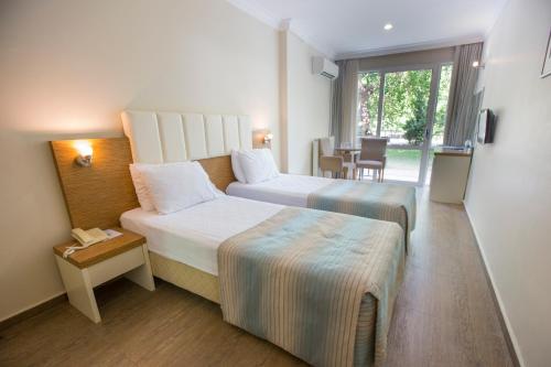 a hotel room with two beds and a table at Balcova Termal Hotel in İzmir