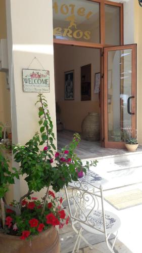 a table and chairs with flowers in front of a store at Eros Beach Hotel in Benitses