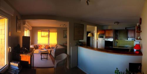 eine Küche und ein Wohnzimmer mit einer Theke in einem Zimmer in der Unterkunft Residence les Goelands in Jullouville-les-Pins