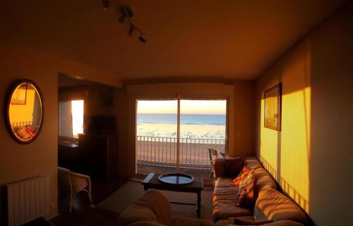 ein Wohnzimmer mit Couch und Blick aufs Meer in der Unterkunft Residence les Goelands in Jullouville-les-Pins