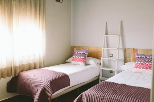 a bedroom with two beds and a book shelf at ALTAIR Turismo Rural in Béjar