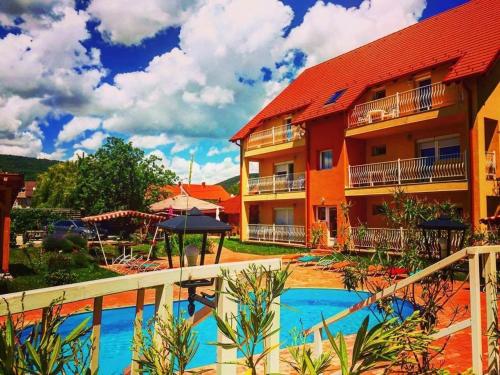 un complejo con piscina frente a un edificio en AndreaApartmanok, en Balatonfüred