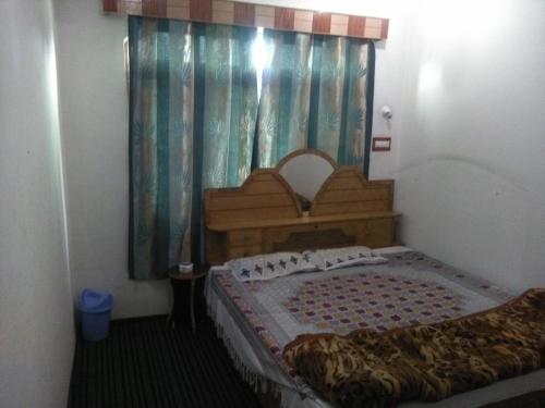 a bedroom with a bed and a window with curtains at Kashmir naaz in Srinagar