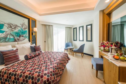 a hotel room with a bed and a table at Adalya Elite Lara Hotel - Ultra All Inclusive in Lara