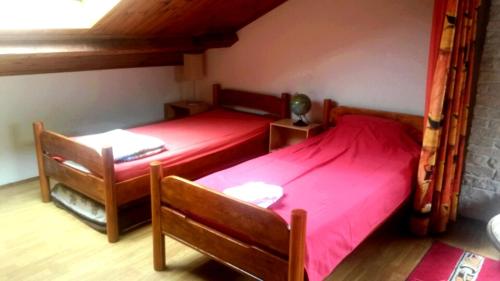 1 dormitorio con 2 camas con sábanas rojas en Chambres d'Hôtes Le Perdigon, en Estang