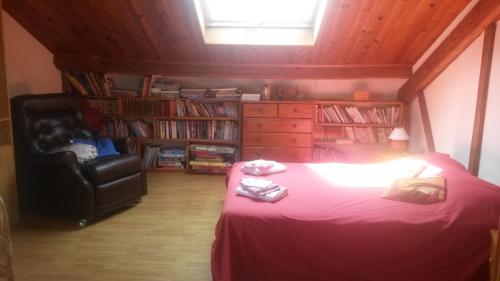 a bedroom with a bed and a chair in a room at Chambres d'Hôtes Le Perdigon in Estang