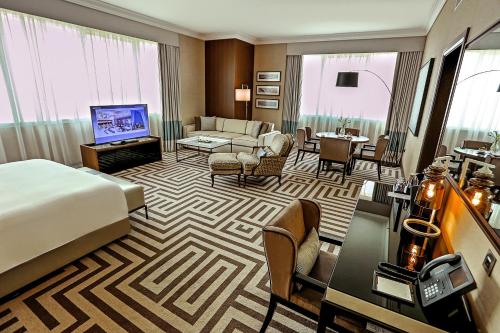 a hotel room with a bed and a living room at Al Maha Arjaan by Rotana in Abu Dhabi