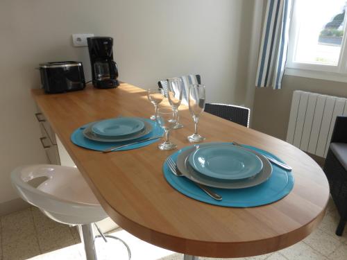 uma mesa de madeira com pratos azuis e copos de vinho em Studio Chez Jose em Albert