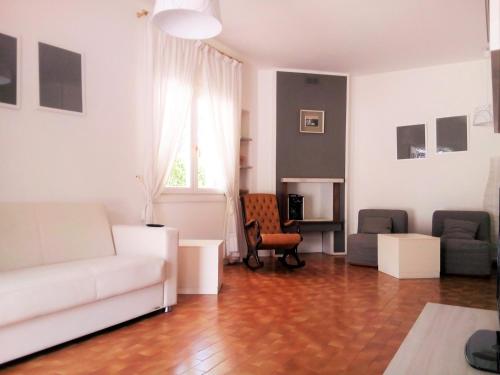 a living room with a white couch and chairs at Hotel Villa Luisa in Lignano Sabbiadoro