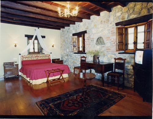 a bedroom with a bed and a table and a piano at El Ama De Llaves in Hontoria