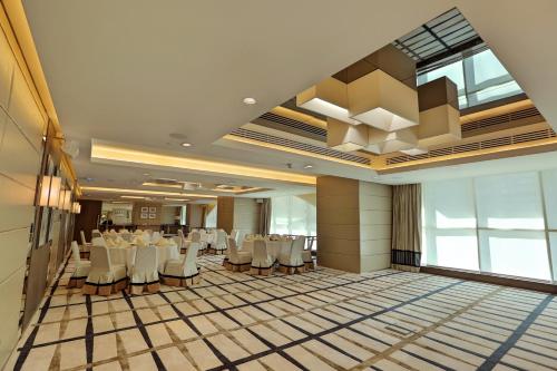 a banquet hall with white tables and chairs at Al Maha Arjaan by Rotana in Abu Dhabi