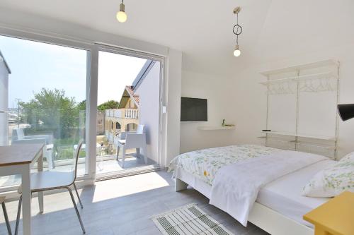a bedroom with a bed and a table and a window at Apartments Villa Navi in Bibinje