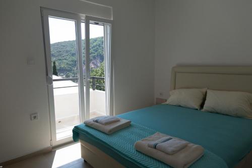 a bedroom with a bed with two towels on it at Del Mar Apartments in Čanj