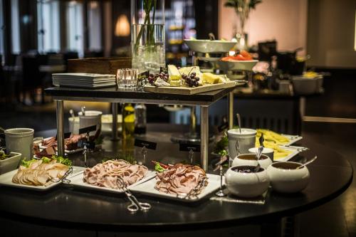 a table with several plates of food on it at Hyatt Place Gothenburg Central in Gothenburg