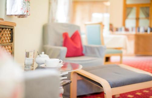 a living room with a coffee table and chairs at Garni Haus Sonnleitn - Adults only in Fuschl am See
