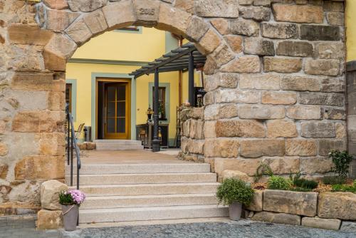 an entrance to a building with a stone wall at Brennereihotel Sponsel in Kirchehrenbach
