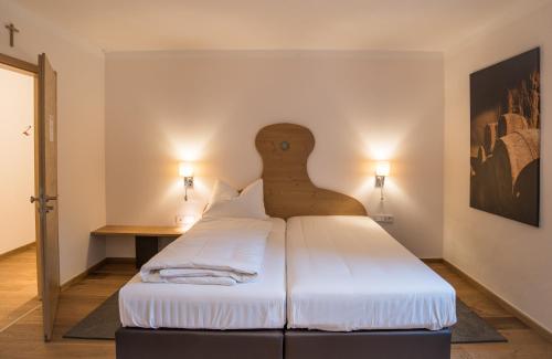 a bedroom with a large bed with a wooden headboard at Brennereihotel Sponsel in Kirchehrenbach